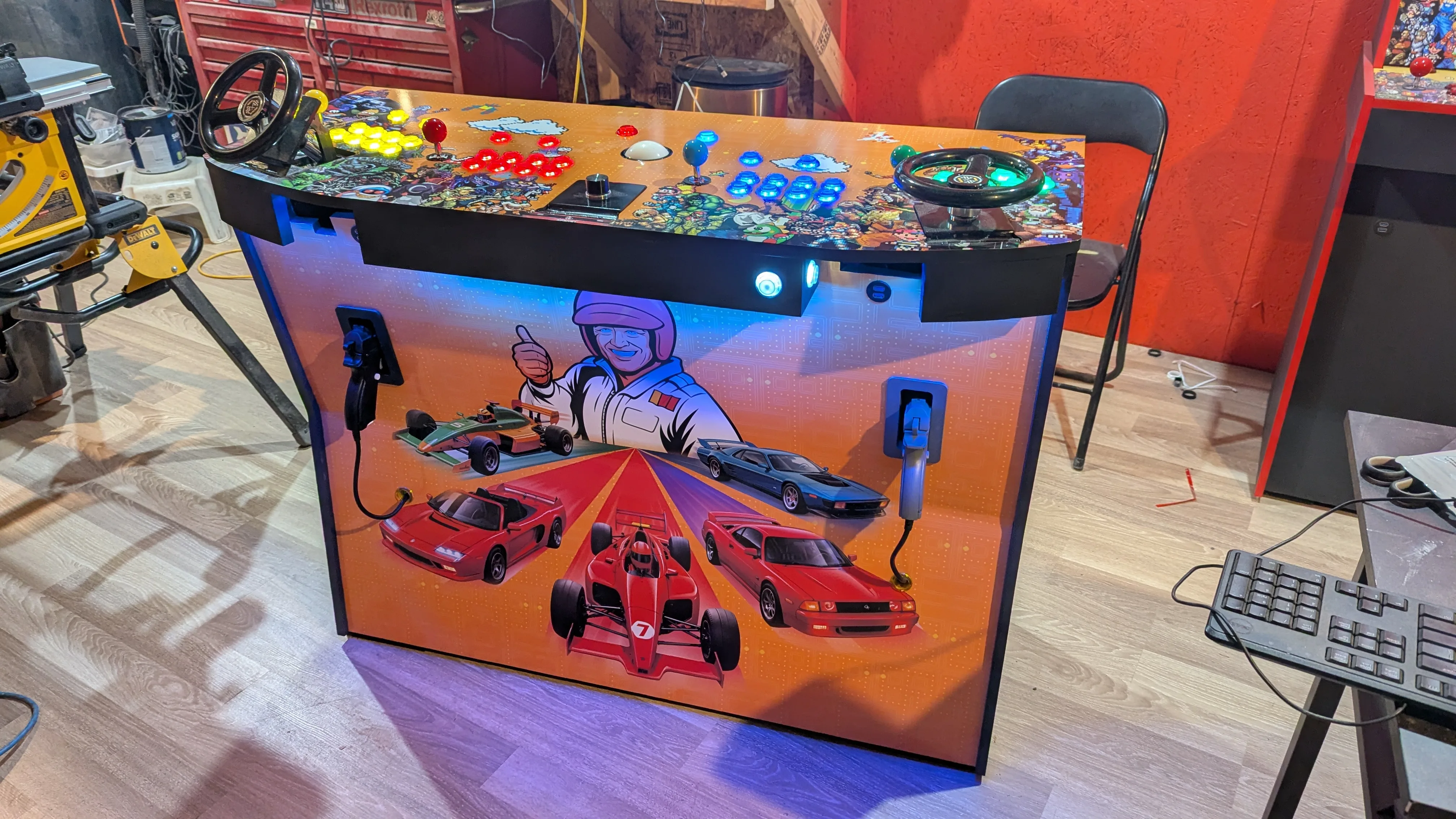 Custom pedestal arcade machine with racing wheels, light guns, and illuminated controls
